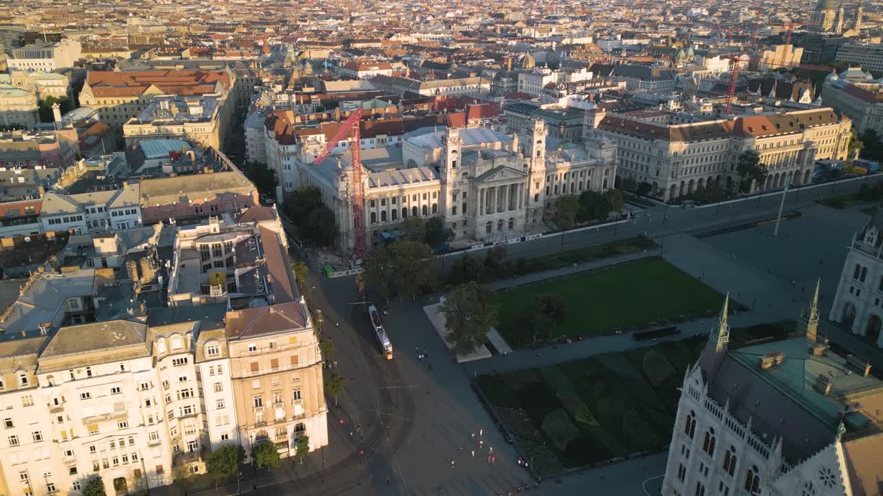vista aérea de pájaros del tranvía amarillo en budapest que pasa por el edificio del parlamento húngaro