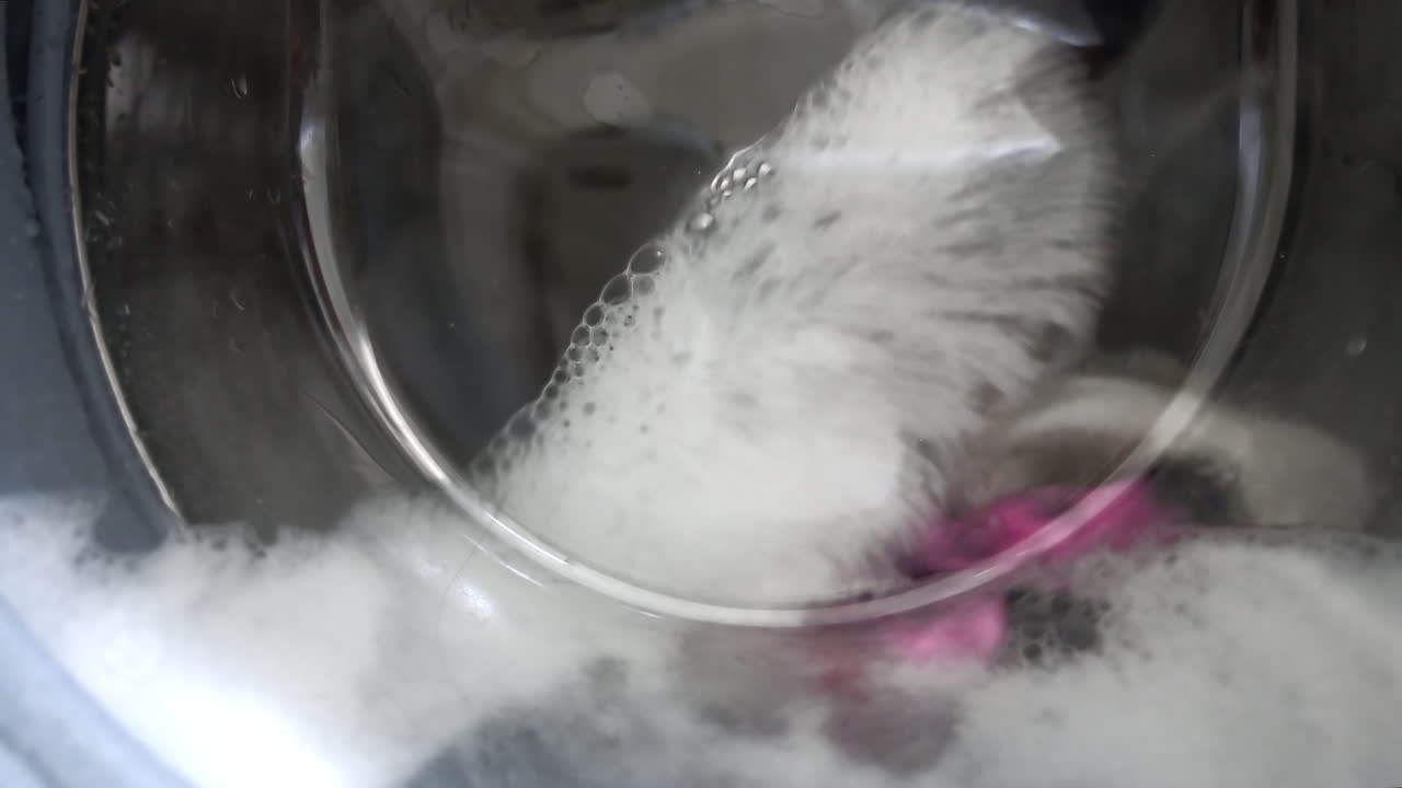 Close up of bubbles forming in a washing machine while clothes are being cleaned