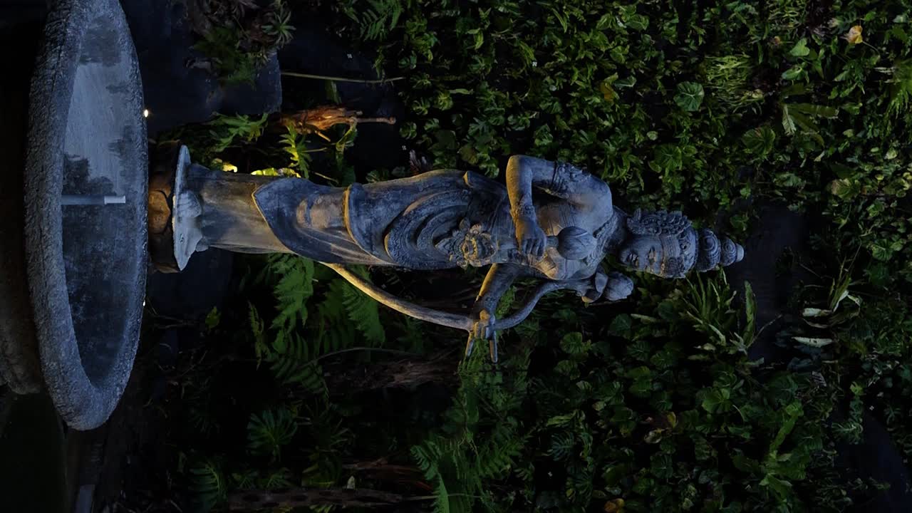 Vertical Parallax shot of a sacred statue in the cultural park of bali indonesia garuda wisnu kencana overlooking fountain and plants
