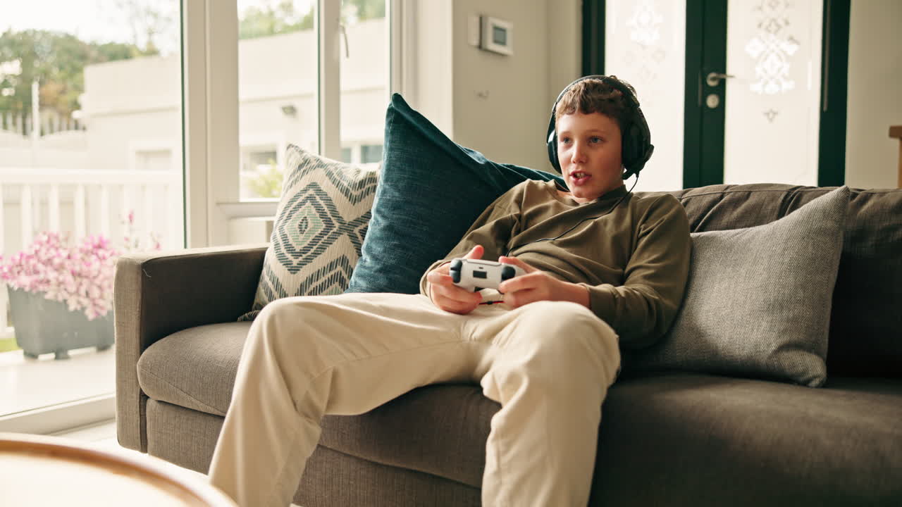 Ragazzo che gioca ai videogiochi sul divano