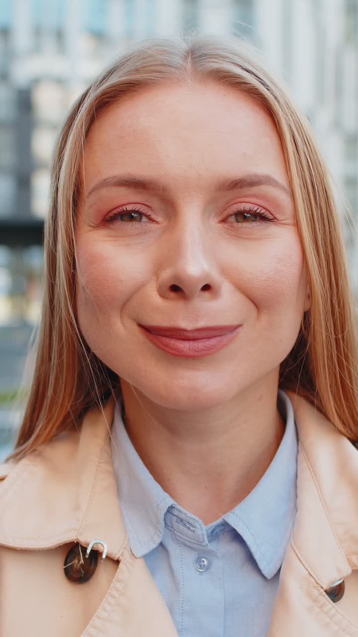 Closeup portrait of happy mature woman face smiling friendly looking at camera on city street