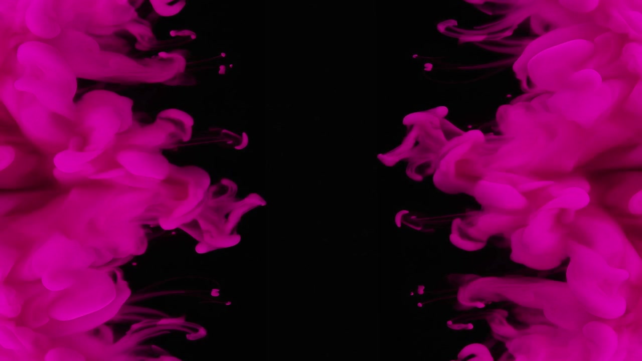 Nuvole di inchiostro rosa che turbinano nell'acqua su sfondo nero