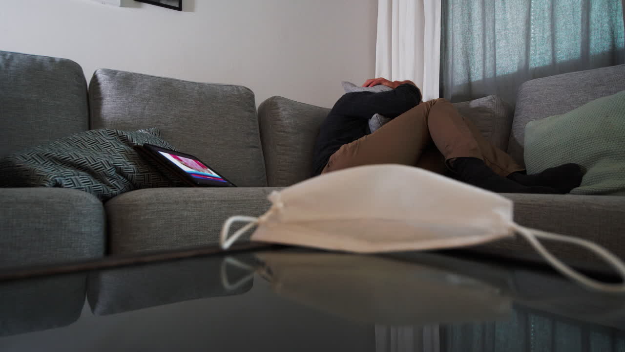 집에 격리된 우울한 남성, covid-19 뉴스에 대한 언론 보도