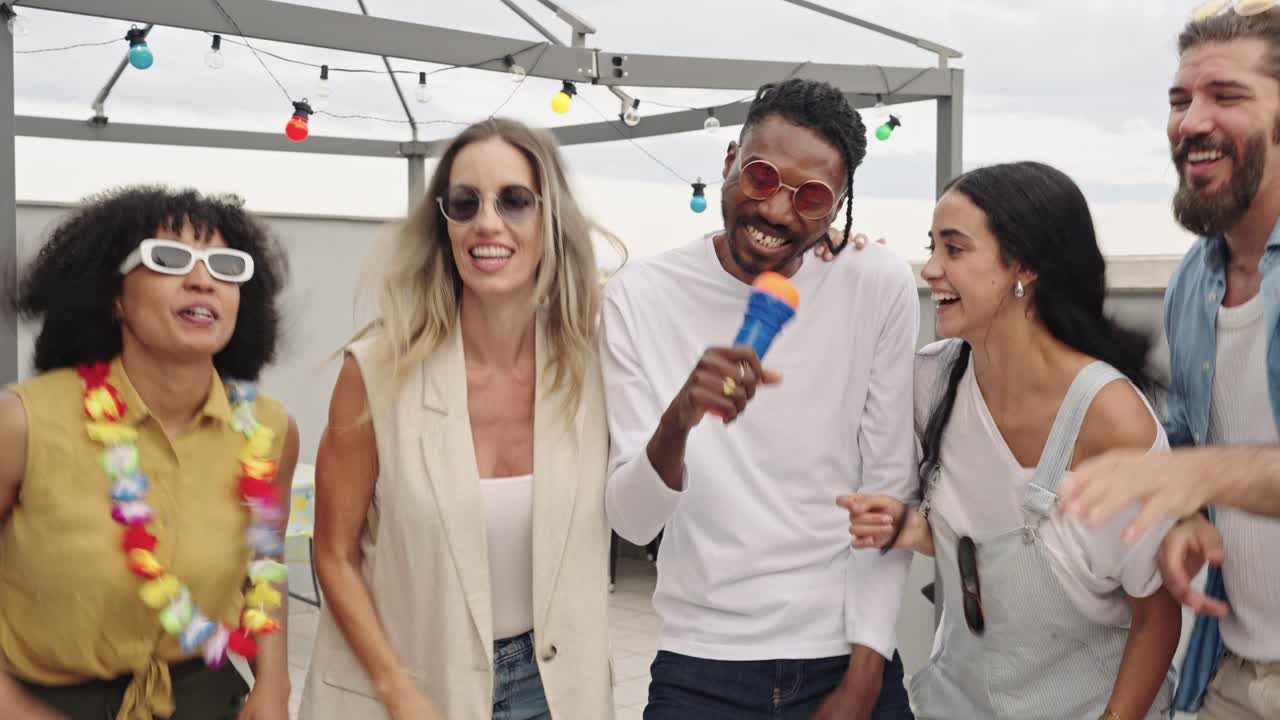 Vennegruppe, der synger og danser til en fest