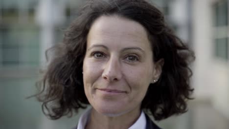 cheerful curly mature lady looking at camera.