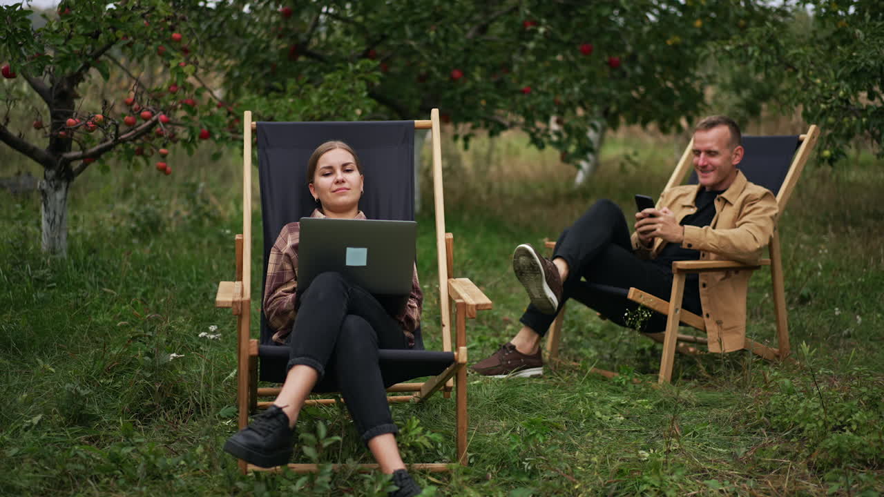 Couple Working Outdoors in an Apple Orchard