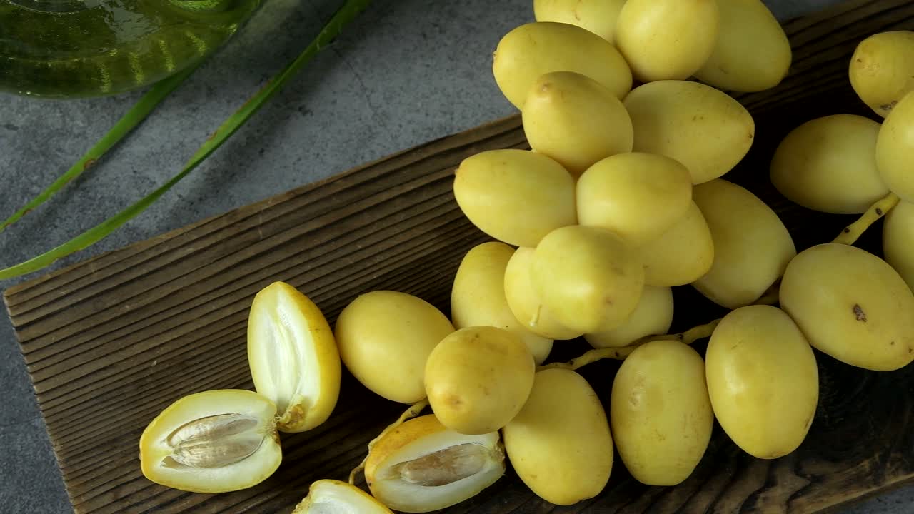las palmeras de dátiles frescas se colocan en la mesa con aceite, concepto de alimentos saludables. palmeras de dátils. frutas crudas de palmieras de dátiles (phoenix dactylifera)