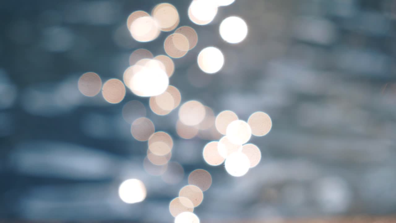 Luci bokeh scintillanti che si riflettono sulla superficie dell'acqua.
