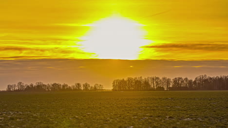 Atemberaubender-Sonnenuntergang-Auf-Einem-Ackerland-Mit-Wäldern-Am-Horizont