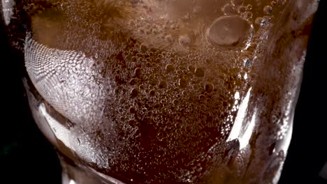 Cola-and-ice-in-glass,-Cola-pouring-into-a-glass-with-ice-cubes