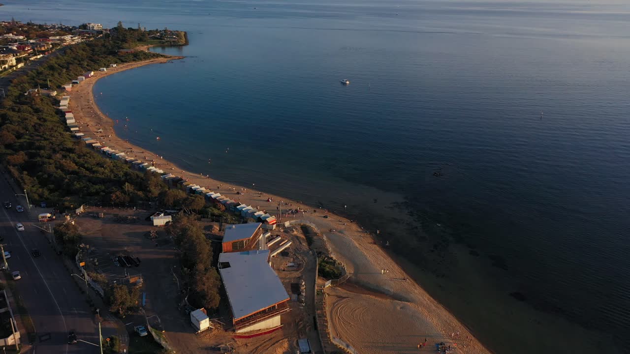 Drone footage flying towards Brighton's colourful bathing boxes that attracts thousands of tourists in Melbourne, Australia