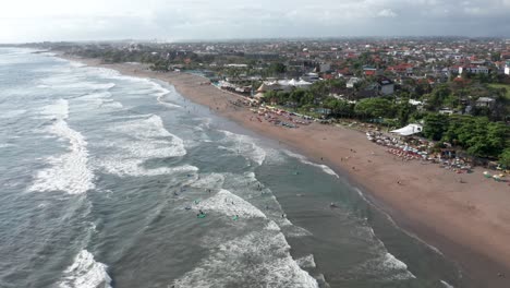 Vista-Aérea-De-Surfistas-Y-Bañistas-En-El-Famoso-Destino-De-Surf-Playa-Canggu-En-Bali,-Indonesia