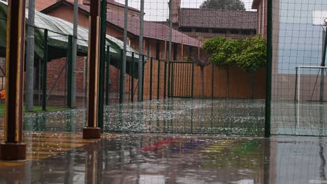 lluvia cayendo en el patio al aire libre sobre el campo de baloncesto en otoño