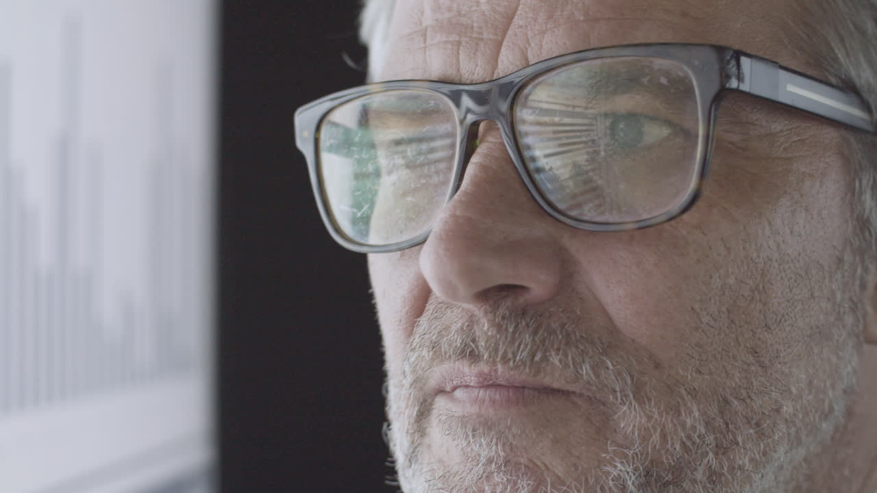 profesional de negocios maduro enfocado en gafas mirando la pantalla