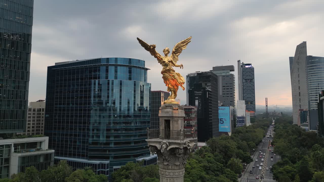 video de avión no tripulado capturando una vista de cerca del ángel de la independencia y los edificios al anochecer en la avenida reform