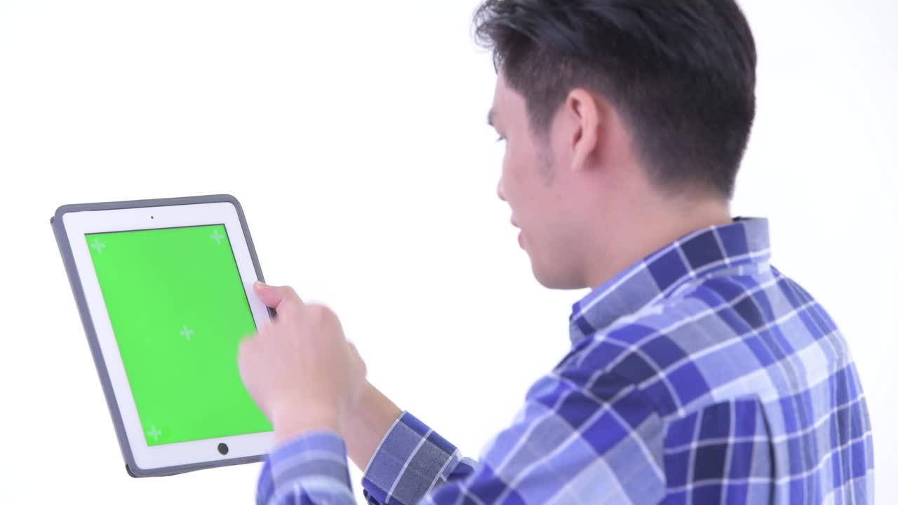 색 배경에 고립 된 녹색 화면 복사 공간을 가진 디지털 태블릿을 사용하는 젊은 잘생긴 아시아 남자의 초상화