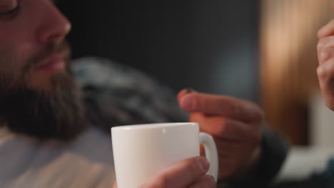 woman gives capsule to bearded husband with heart diseases