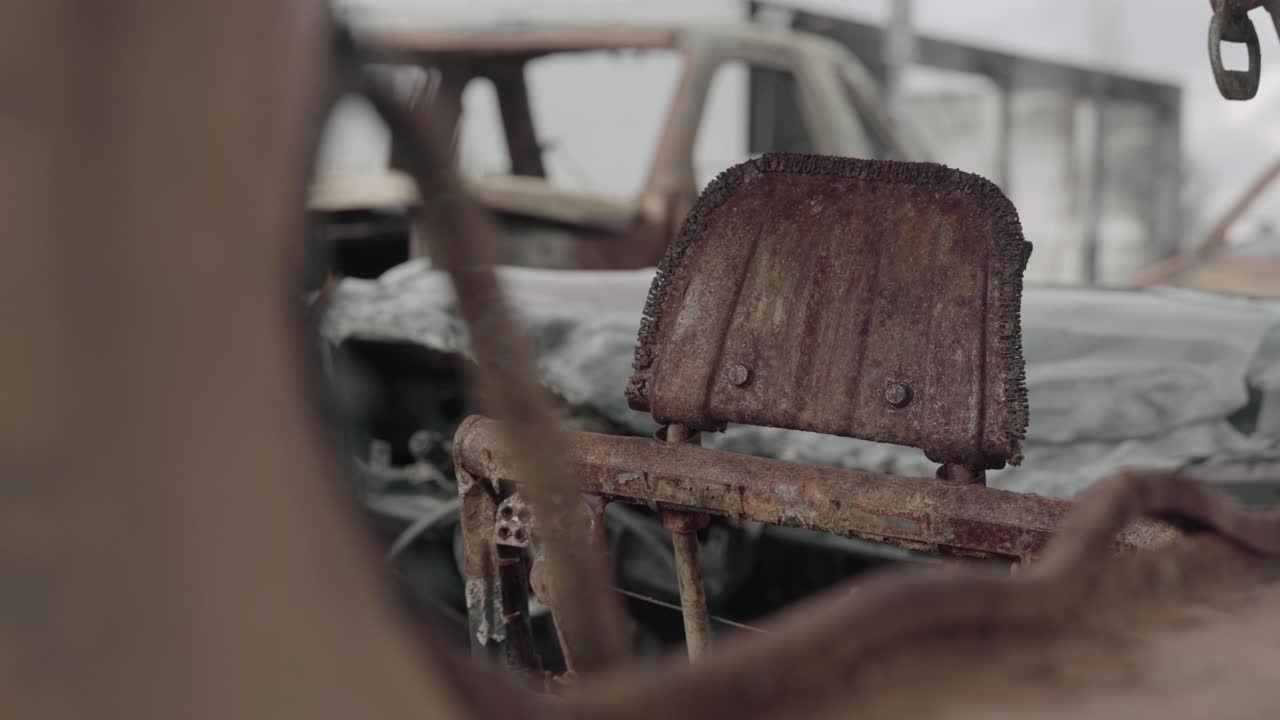 창문을 통해 본 카시트 헤드레스트 뒷면 - 산불로 인해 녹슬고 불에 탔습니다 - 4k