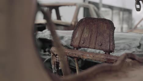 Back-of-a-Car-Seat-Headrest-Viewed-through-a-Window---Rusted-over-and-Burned-due-to-Wildfire---4K