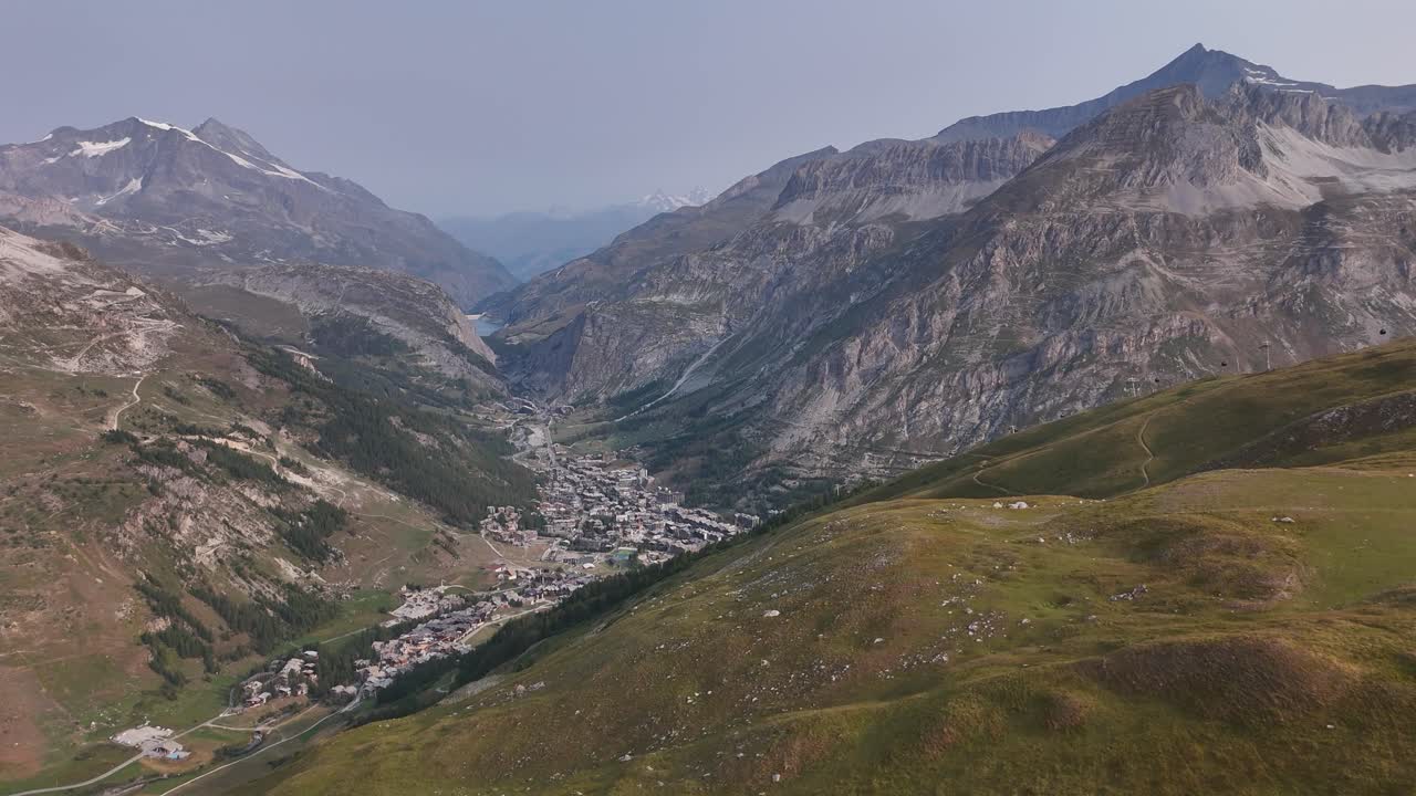Drone che sorvola un prato di montagna con una valle in lontananza in 4K
