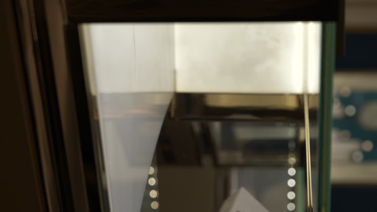 유리 보석 매장 디스플레이에서 비싼 보메 메르시에 시계를 가져가는 수직 손