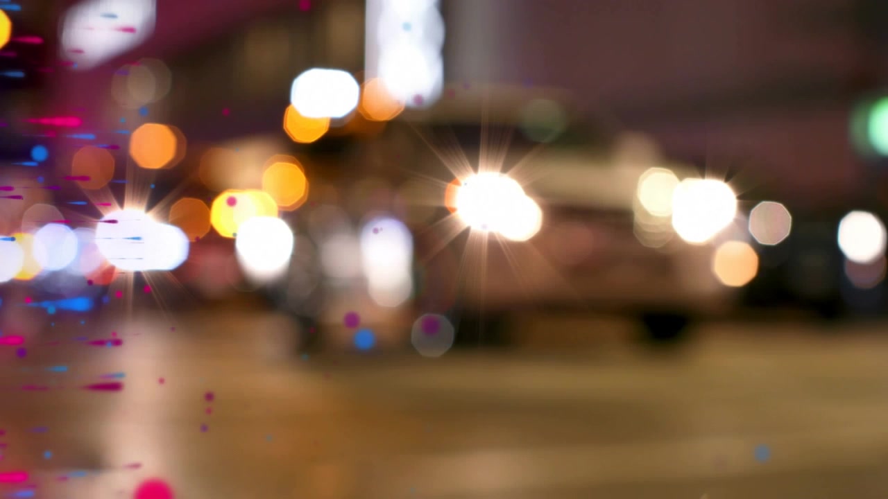 Animazione di punti colorati che si muovono su un paesaggio urbano notturno sfocato.
