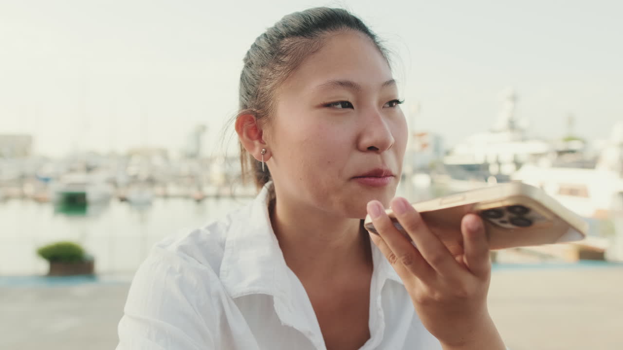 Woman using smartphone near marina