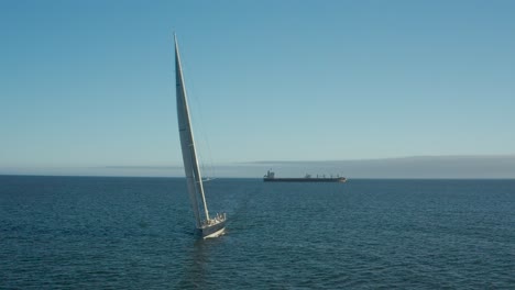 Yate-Wally-De-100-Pies-Navegando-Hacia-La-Cámara,-Buque-De-Carga-A-Distancia,-Océano-Atlántico