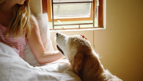 woman sitting with her dog on bed 4k