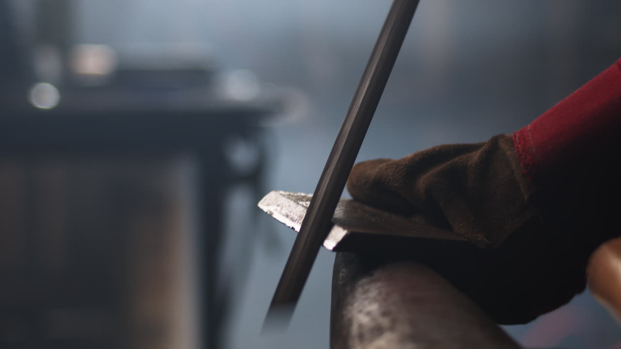 un herrero lima metal sobre un yunque en un taller de artesanos