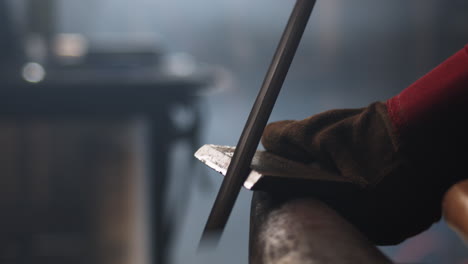 a blacksmith files metal on an anvil in an artisans workshop