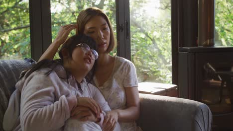 Asian-mother-and-daughter-embracing-and-lying-on-couch