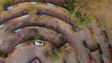 vista aérea del laberinto circular al aire libre antiguo, abandonado y vacío hecho de troncos de madera coloridos