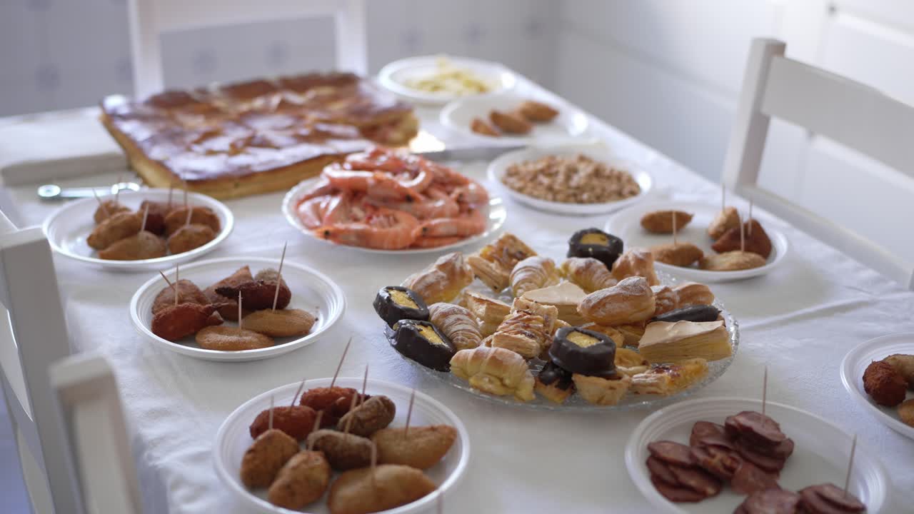 table set with assorted appetizers, seafood, and pastries for a festive meal