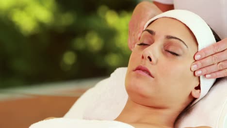 bonita morena recibiendo un masaje facial