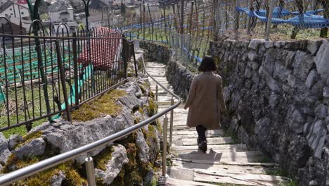 young asian woman walking down a long staircase on a hike trail in switzerland