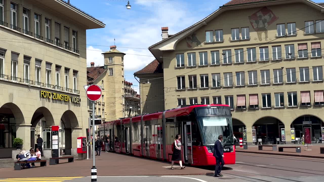 City scene of Bern Town with Crossing pedestrian and tram in center. Slow motion wide shot. Beautiful sunny day in capital of Switzerland.