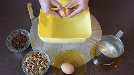 woman's hand breaking an egg with a knife