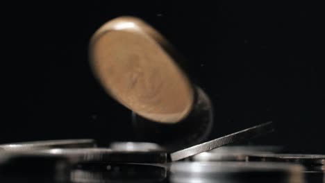 isolated metal coins on black background falling on surface