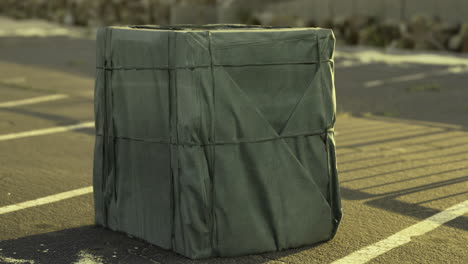 mysterious green cube stands alone in an empty parking area during midday