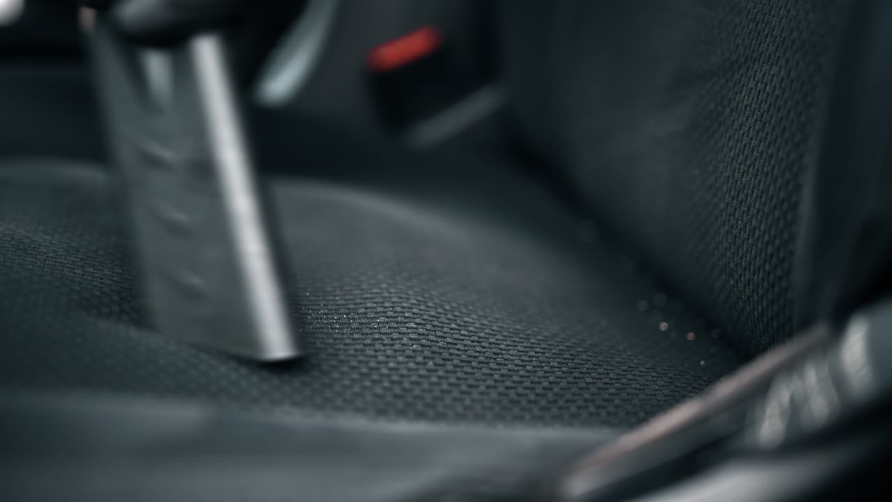 Working cleaner at car wash. Cleaning out crumbs using a professional vacuum cleaner. Slow motion