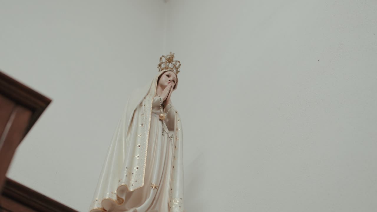 Primo piano di una statua della Vergine Maria incoronata esposta all'interno.