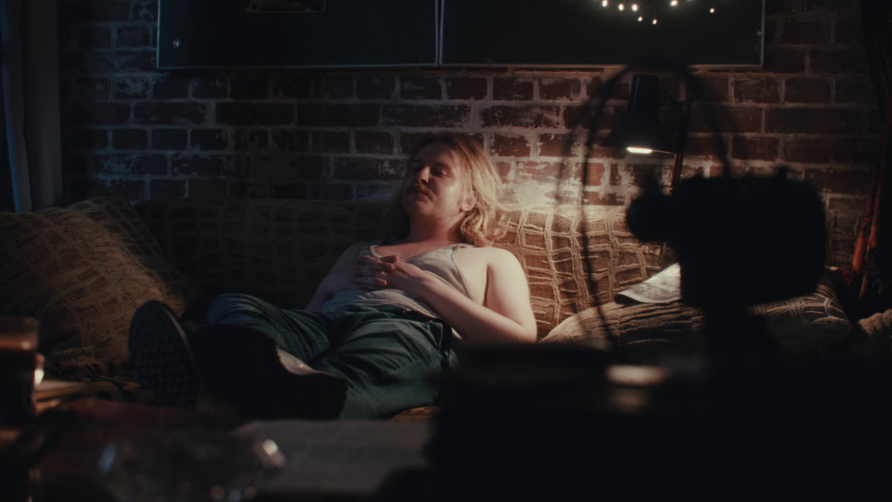 밤에 소파에서 자고 있는 남자