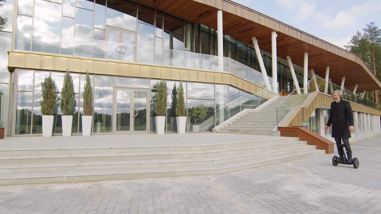 Man Riding a Self-Balancing Scooter Outside a Modern Office Building