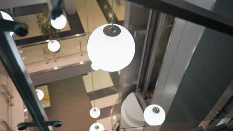 first-person view capturing the staircase with modern glass railings and the surrounding indoor environment. the camera focuses on the sleek design of the stairs and the bright, decorated background