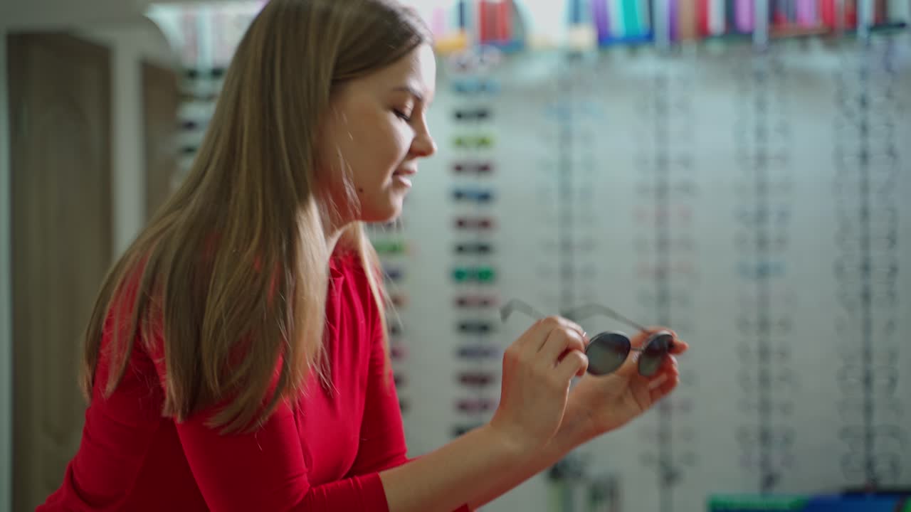 Woman choosing sunglasses. Young woman at optician with glasses