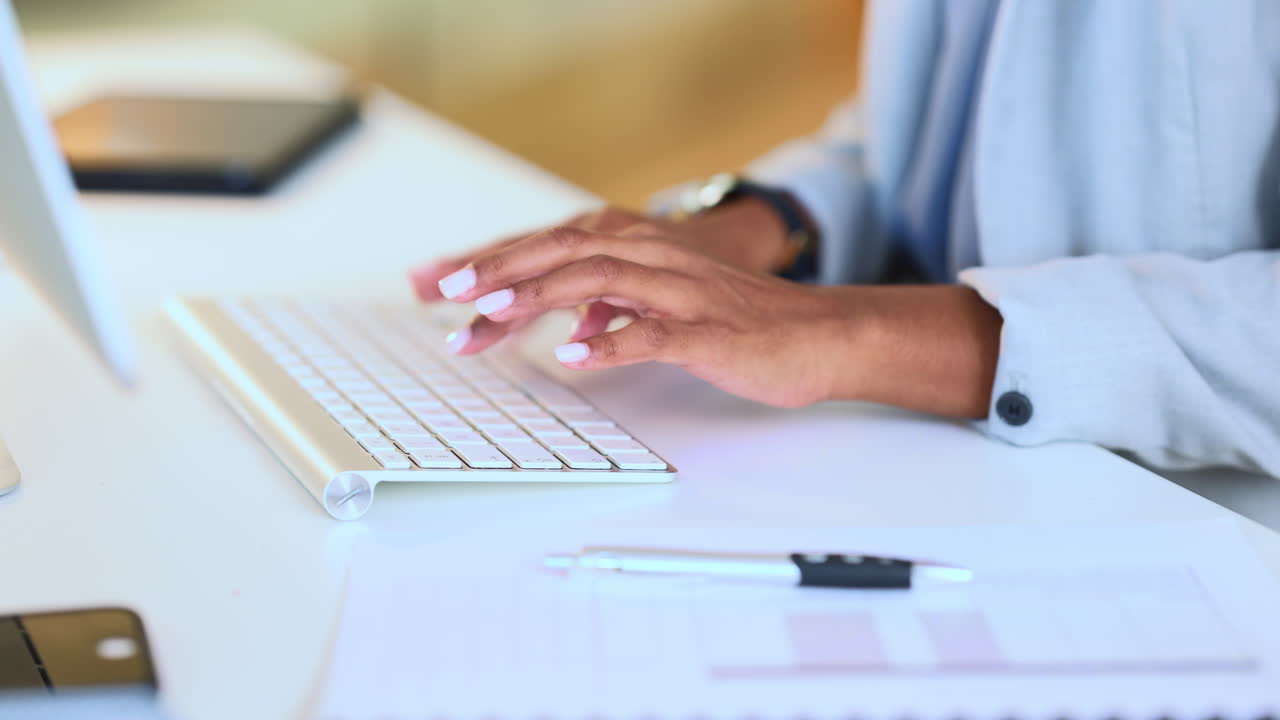 A businesswoman's hands typing on a keyboard