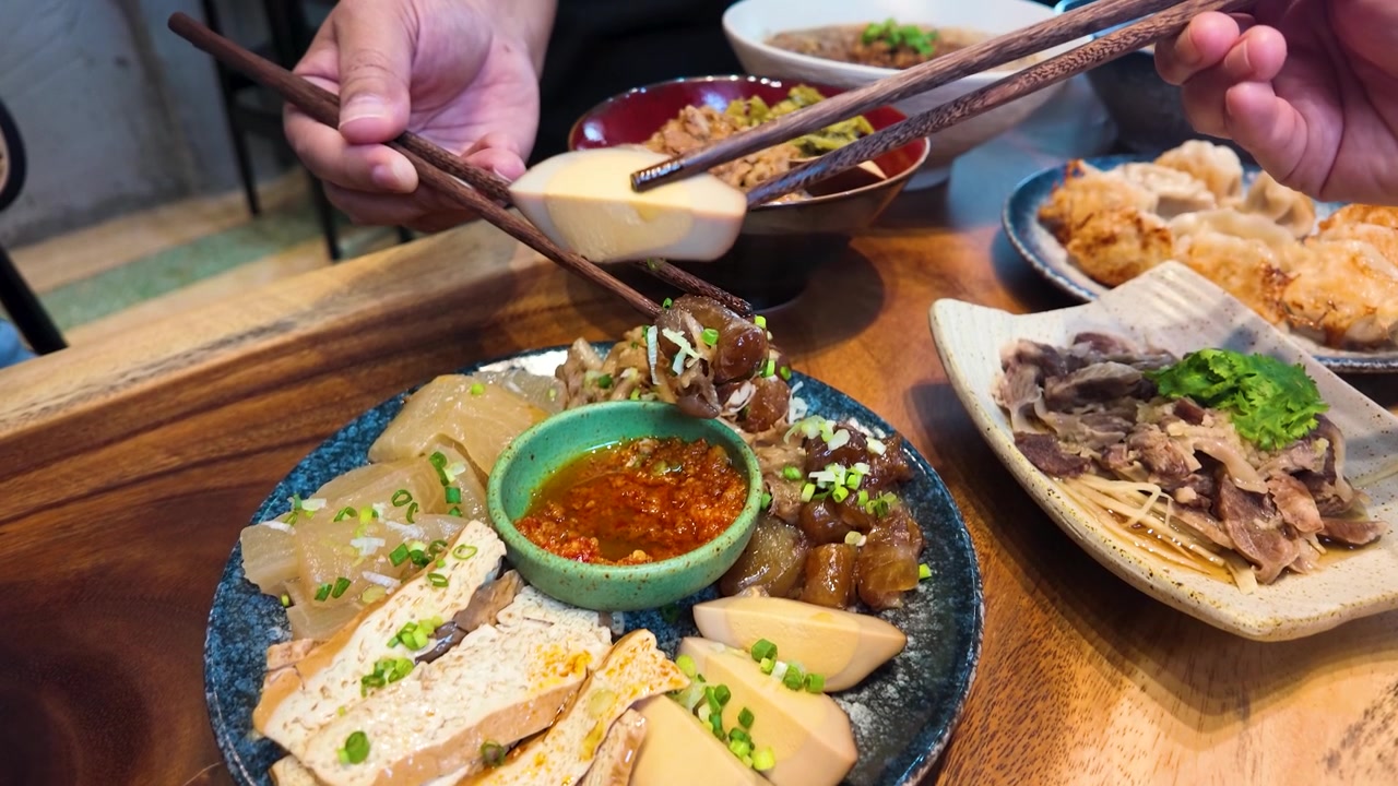 Jarak Dekat Tangan Menggunakan Sumpit untuk Mencocol Babi dan Telur Rebus Taiwan di Bangkok, Thailand
