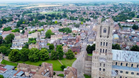 aerial: ely cathedral church gate top view with urban cityscape, tracking drone shot