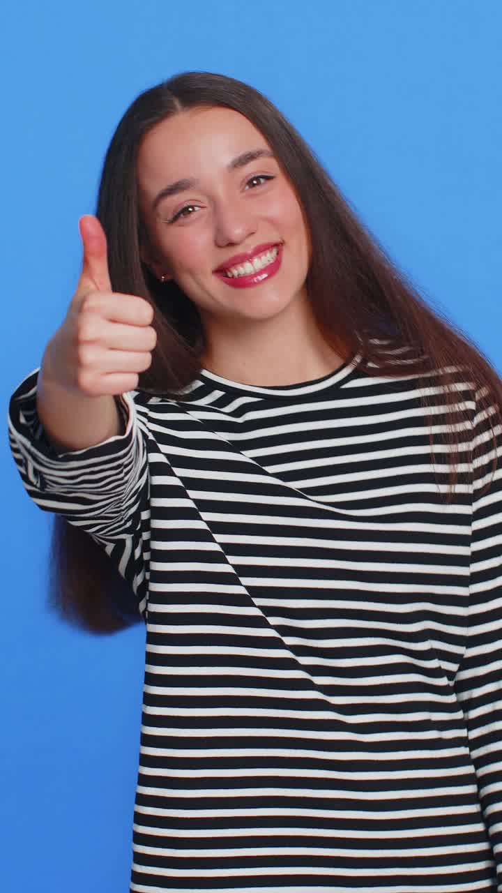 la mujer caucásica levanta el pulgar, está de acuerdo, da una respuesta positiva, recomienda el anuncio, le gusta, buena idea.